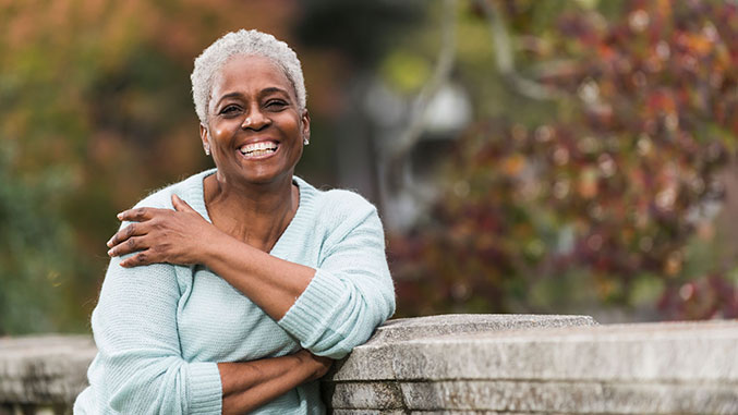 Woman smiling while leaning against a wall
